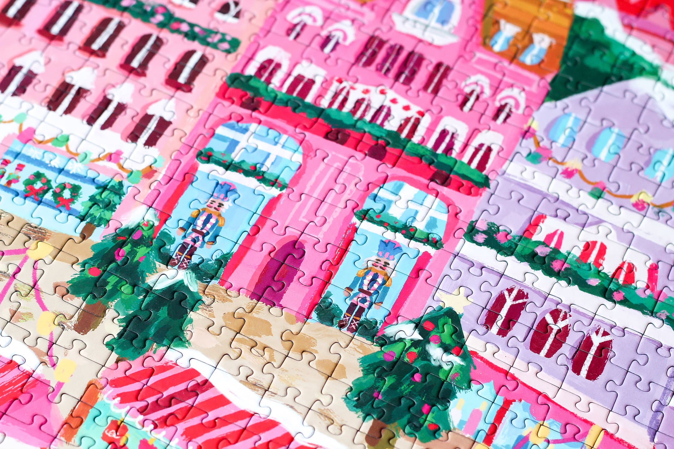 1000-teiliges Puzzle für Erwachsene, das den Weihnachtsmarkt in Riga zeigt. Auf dem Platz befinden sich pinke Stände und geschmückte Weihnachtsbäume.