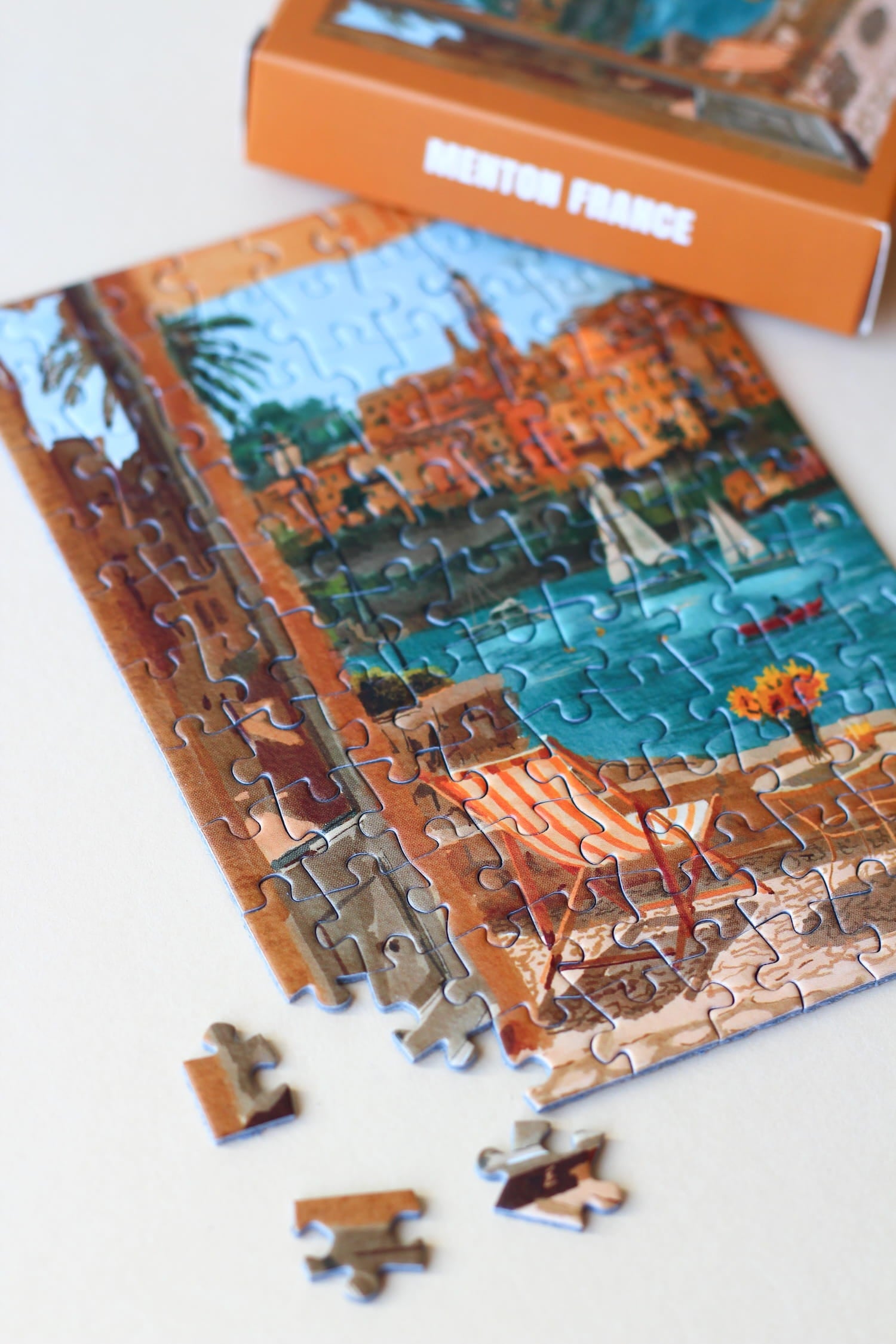Illustration eines Balkons mit Blick auf Meer, Segelboote und die Stadt Menton in Südfrankreich, als 99-Teile Minipuzzle von Piecely