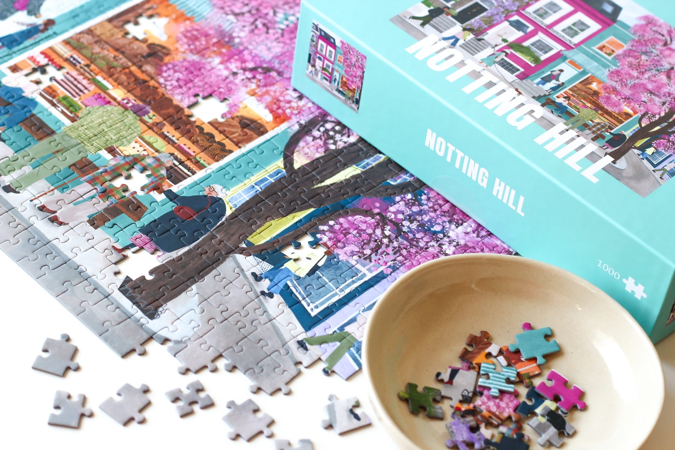 Illustration bunter Häuser in Notting Hill mit Kirschblütenbaum und Menschen auf der Straße, als 1000-Teile Puzzle von Piecely