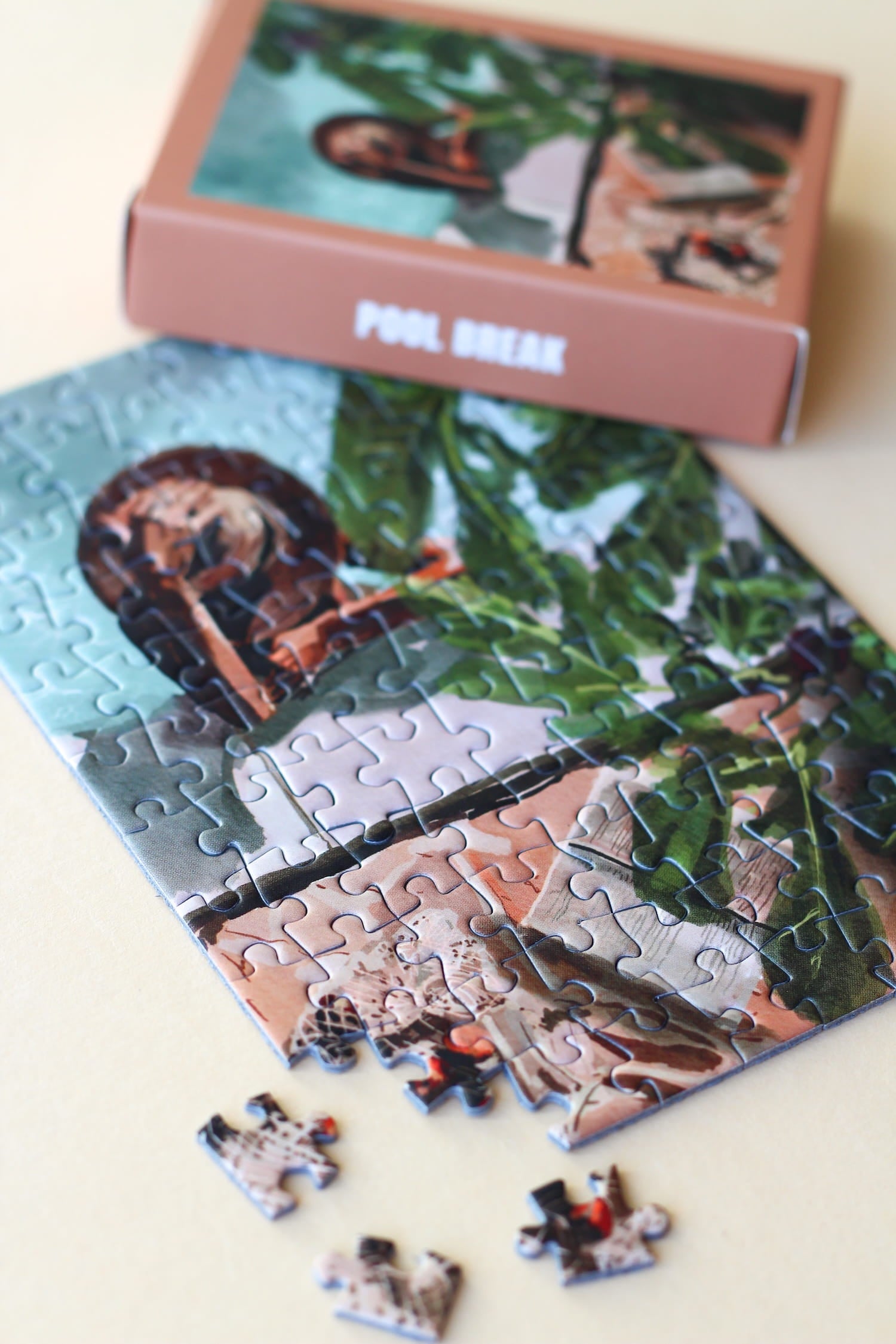 Illustration einer Frau am Pool mit Pflanzen und Buch in ruhiger Atmosphäre, als 99-Teile Minipuzzle ‚Pool Break‘ von Piecely