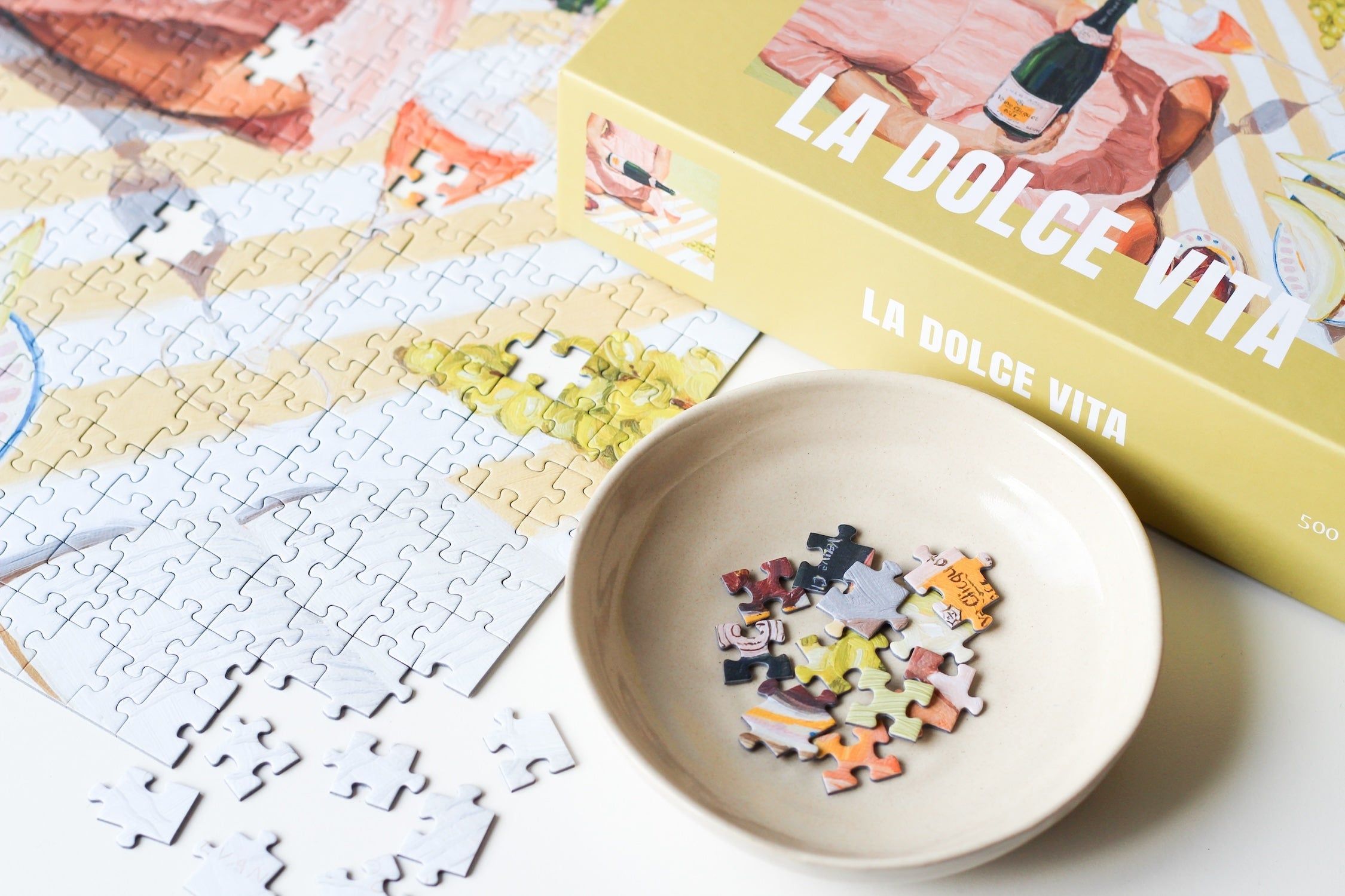 500-teiliges Puzzle für Erwachsene, das eine Frau beim Picknicken von Trauben, Feigen, Melone und Champagner zeigt.