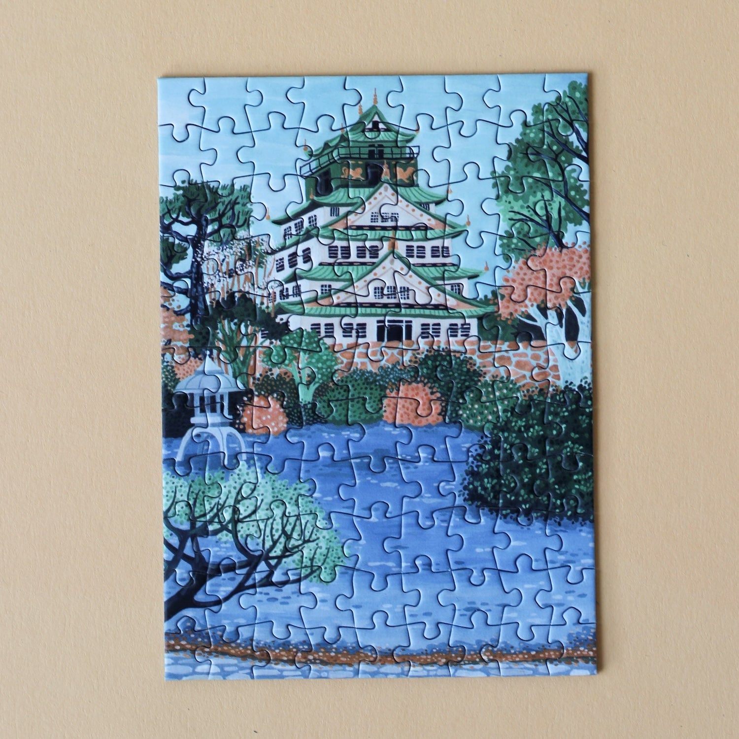 Plastikfreies Minipuzzle für Erwachsene, das die Burg Osaka in Japan in pastelligen Blau- und Grüntönen zeigt.