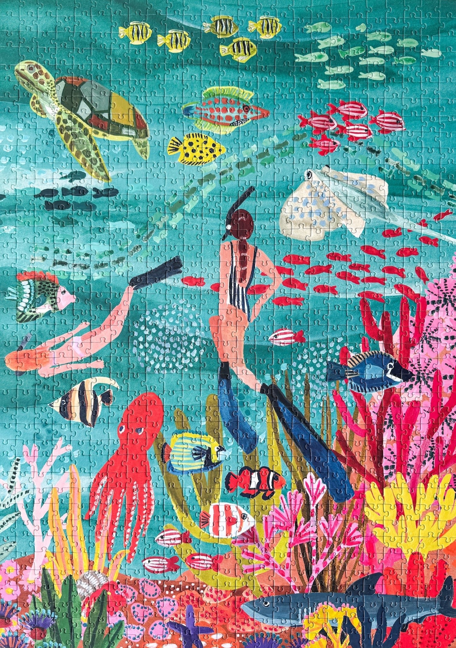 10000-teiliges, nachhaltiges Puzzle für Erwachsene, das eine farbenfrohe Unterwasserlandschaft mit Taucherinnen, Fischen, einem Hai, einer Schildkröte, einem Oktopus und einem Rochen zeigt.