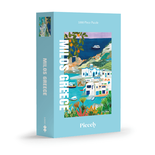 Außergewöhnliches 1000-Teile-Puzzle für Erwachsene, das einen Teil der griechischen Insel Milos zeigt. Zu sehen sind weiße Häuser and der Küste, Orangenbäume und Schiffe und Boote auf dem Meer.