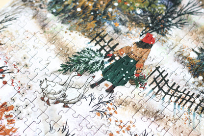 500-Teile-Puzzle „Homecoming“ von Piecely – Illustration einer winterlichen Landschaft mit Frau und zwei Gänsen auf einem verschneiten Weg, auf grauer Verpackung.