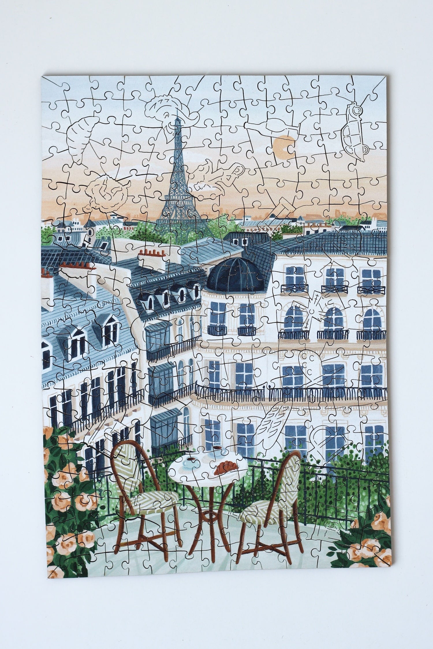 250-Teile-Holzpuzzle „Paris“ von Piecely – Illustration eines Pariser Balkons mit Frühstückstisch, Rosen und Eiffelturm im Hintergrund, von Ellen Gözel-Niehoff.