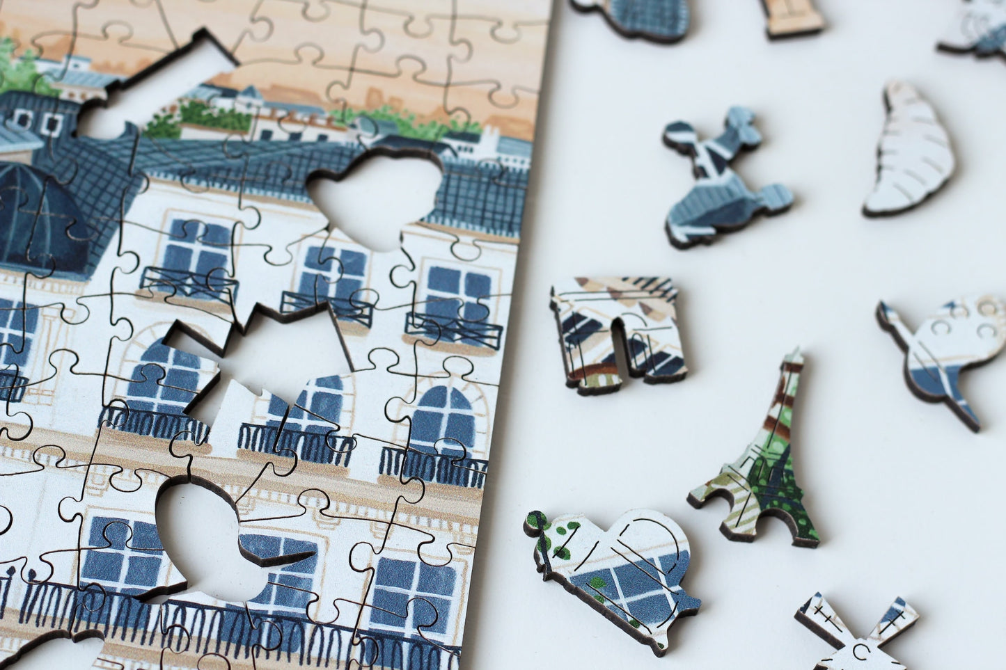 250-Teile-Holzpuzzle „Paris“ von Piecely – Illustration eines Pariser Balkons mit Frühstückstisch, Rosen und Eiffelturm im Hintergrund, von Ellen Gözel-Niehoff.