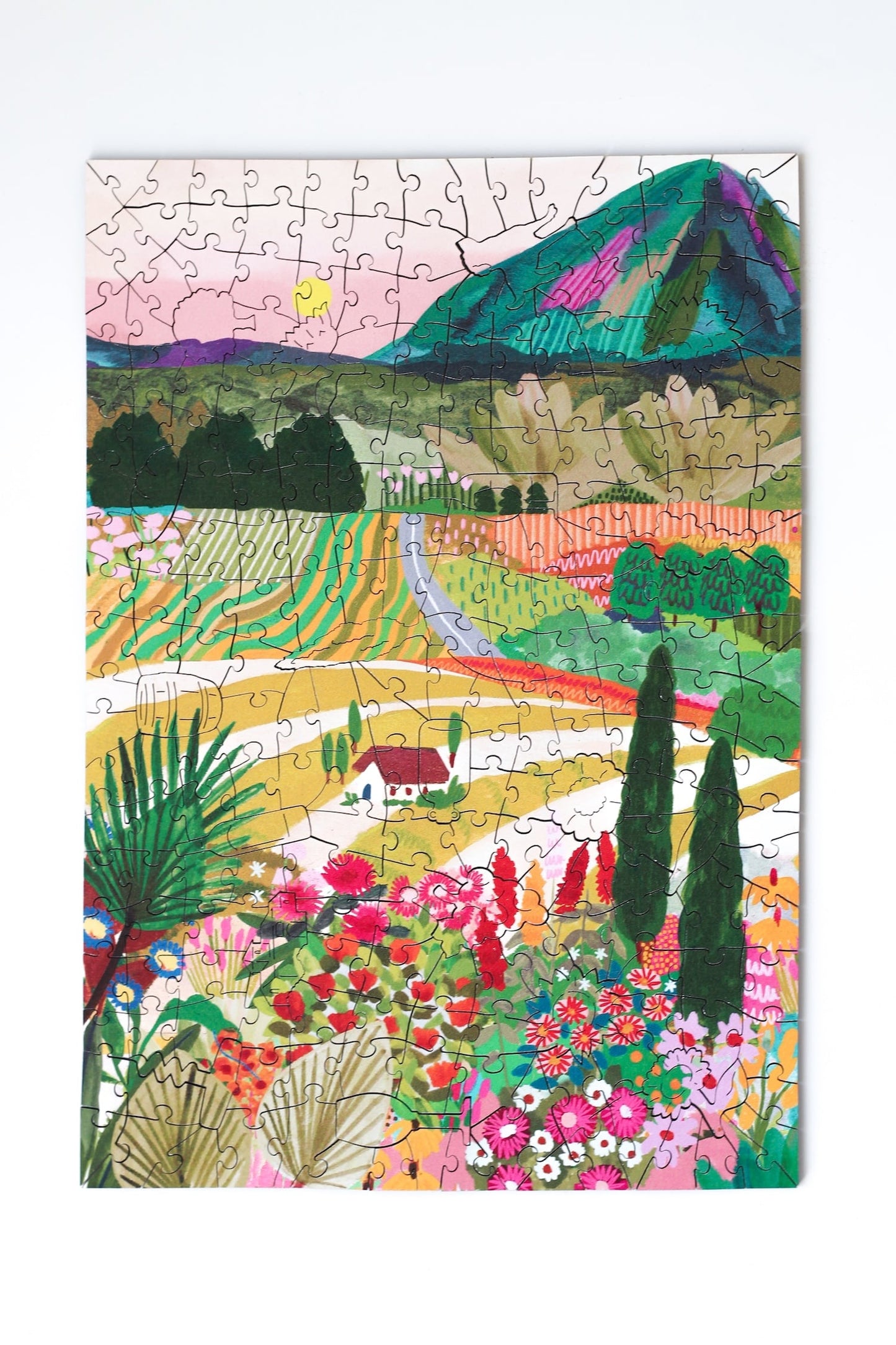 250-Teile-Holzpuzzle „Summer in Puglia“ von Piecely – Illustration einer mediterranen Sommerlandschaft mit Blumen, Feldern und Bergen, von Hebe Studio.
