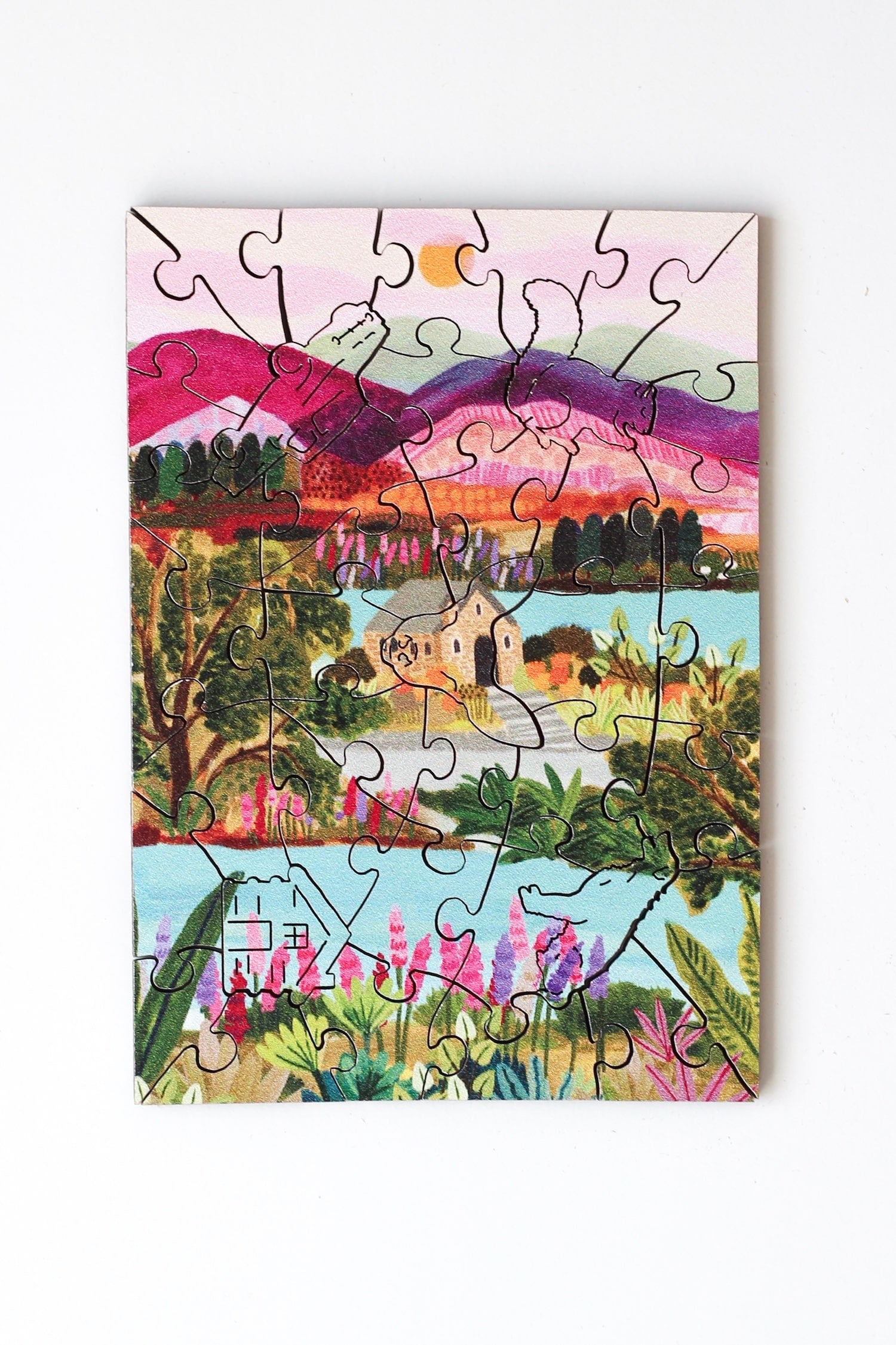 40-Teile-Holzpuzzle „Lake Tekapo“ von Piecely – Illustration einer neuseeländischen Landschaft mit Bergen, See und Kirche, von Hebe Studio.