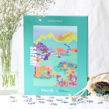 Nachhaltiges 500-Teile-Puzzle für Erwachsene, das eine Collage aus Bergen, wilden Tieren und blühenden Pflanzen zeigt.