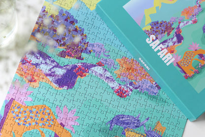 Nachhaltiges 500-Teile-Puzzle für Erwachsene, das eine Collage aus Bergen, wilden Tieren und blühenden Pflanzen zeigt.