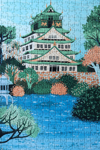 Plastikfreies Puzzle für Erwachsene, das die Burg Osaka in Japan in pastelligen Blau- und Grüntönen zeigt. 