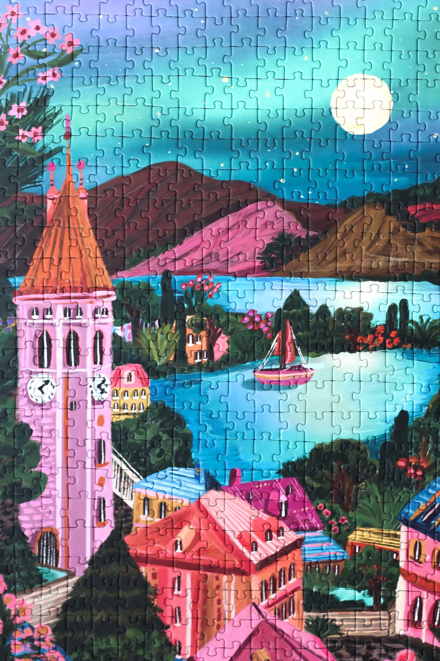 Plastikfreies Puzzle für Erwachsene, das die Stadt Thun in der Schweiz bei Nacht zeigt. Der Vollmond spiegelt sich im Wasser und der Kirchturm ragt hoch über die Stadt.