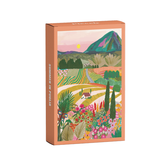 Plastikfreies Minipuzzle für Erwachsene, das die bunte Landschafts Apuliens in Italien zeigt. Zu sehen sind ein Haus, die Berge, bunte Blumen, Felder und die untergehende Sonne