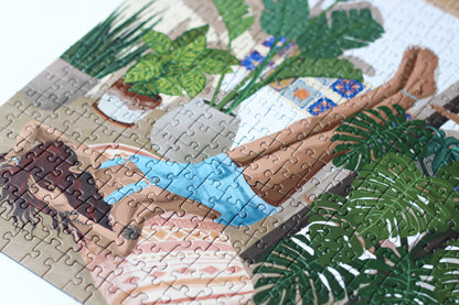 Nachhaltiges, plastikfreies Puzzle für Erwachsene, das eine Frau auf dem Boden liegend zeigt. An der Wand befinden sich Regale mit Zimmerpflanzen.